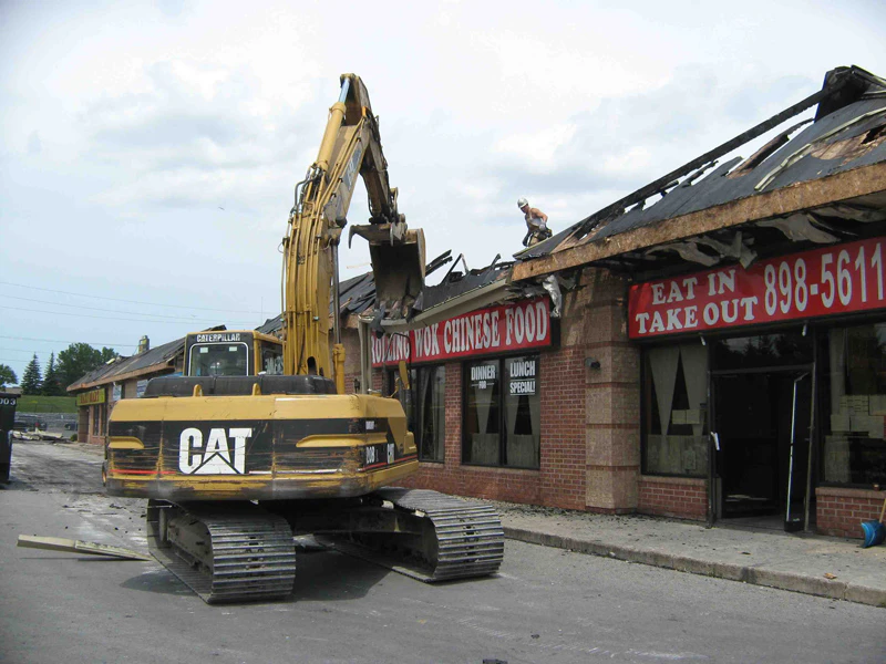Excavator-in-Front-of-Commercial-Plaza-with-Fire-Damage