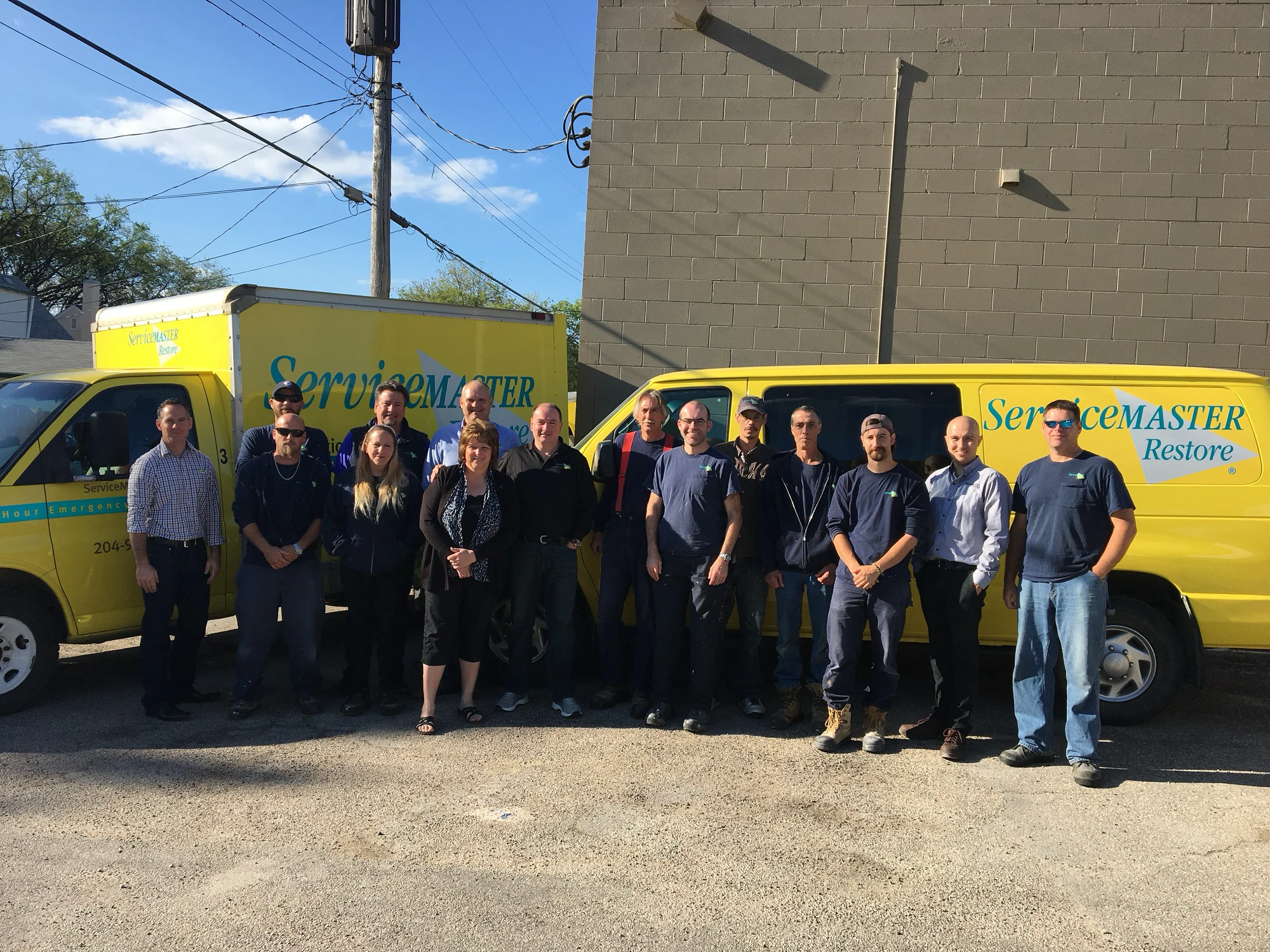 ServiceMaster-group-photo-in-front-of-yellow-ServiceMaster-vehicles