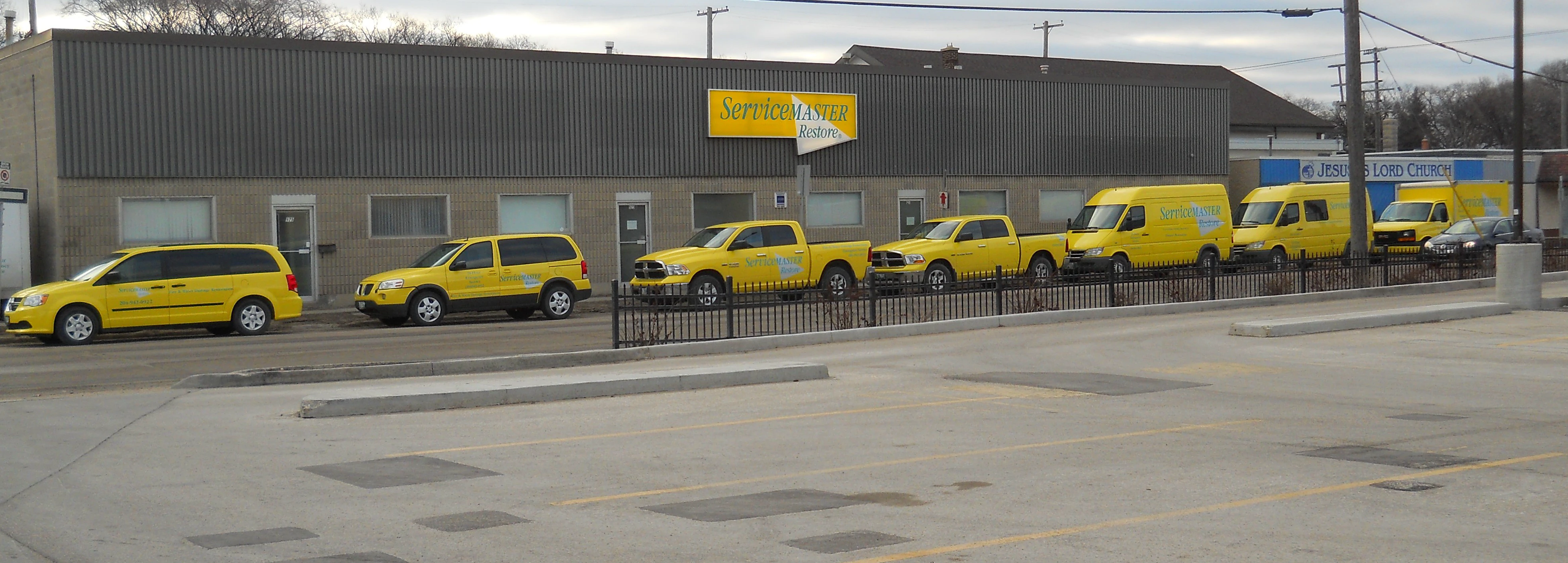 Row-of-yellow-ServiceMaster-vehicles-outside-ServiceMaster-building